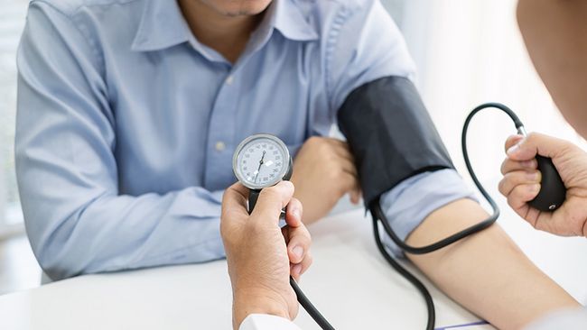 Ein Arzt misst einem Patienten den Blutdruck.