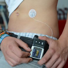 Ein Junge stellt seine Insulinpumpe ein.