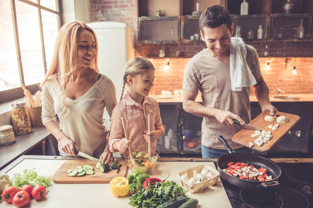 Eine junge Familie beim gemeinsamen Kochen in einer Küche