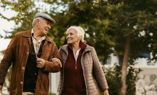 Ein älteres,vglücklich aussehendes Paar bei einem gemeinsamen Spaziergang.