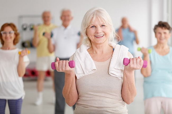 Ältere Frauen und Männer mit Hanteln beim Aerobic.