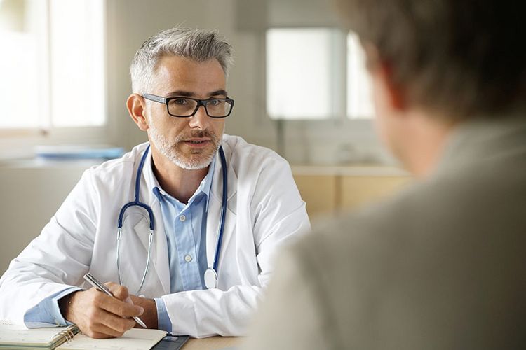 Ein Arzt in einem Gespräch mit einem Patienten.