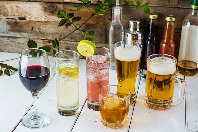 Auf einem Tisch stehen verschiedene Gläser mit Alkohol.