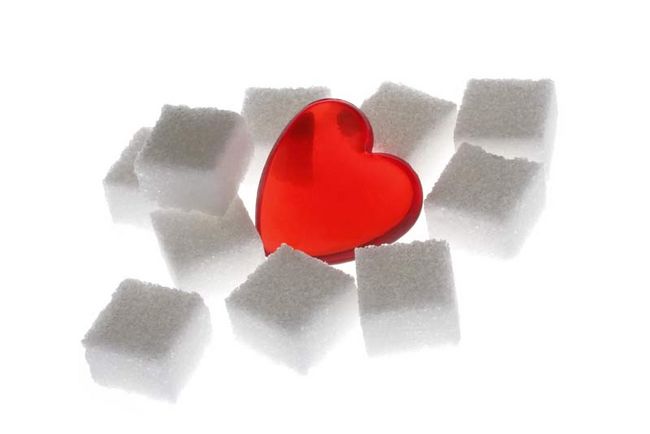 Zwischen mehreren Zuckerwürfeln liegt ein rotes Herz.