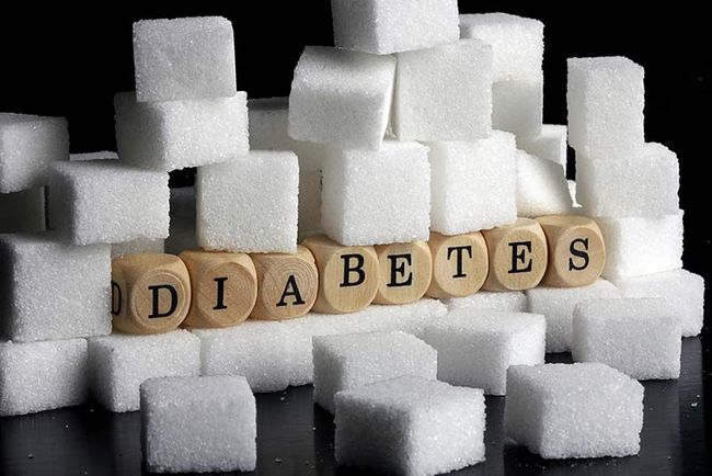 Zwischen aufgestapelten Zuckerwürfeln liegen Würfel mit der Beschriftung "Diabetes".