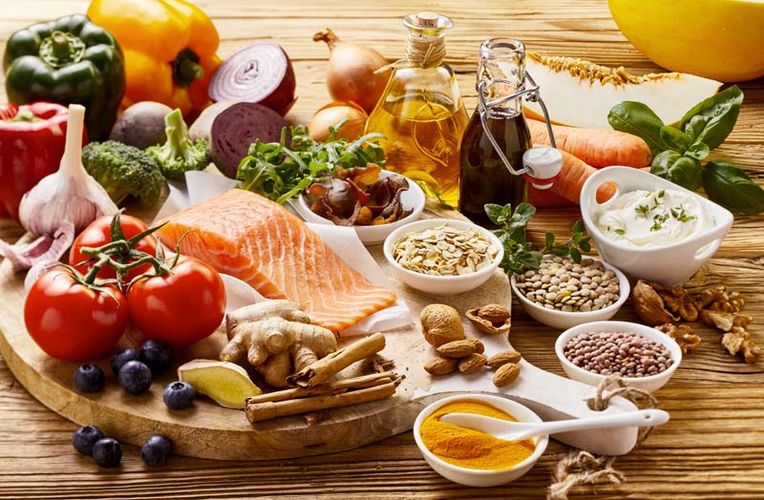 Zusammenstellung verschiedener Lebensmittel wie Gemüse, Fisch, Linsen und Öl, die typisch für die mediterrane Ernährungsweise sind.
