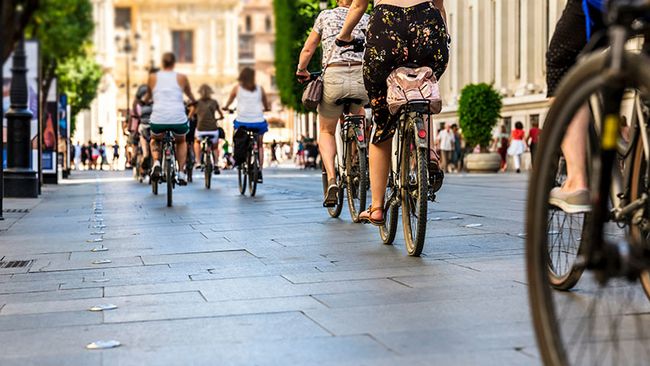 Mehrere Personen fahren mit dem Fahrrad durch eine Stadt.