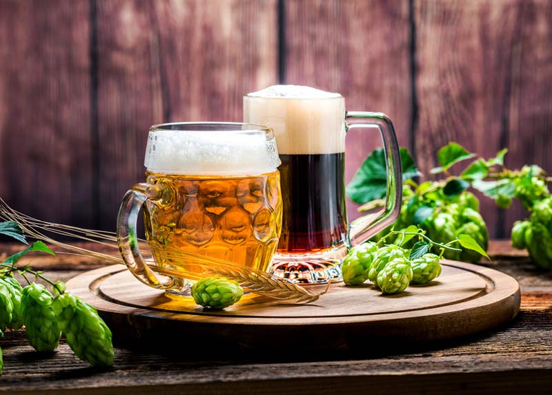Zwei Gläser gefüllt mit Bier stehen auf einem Tisch.